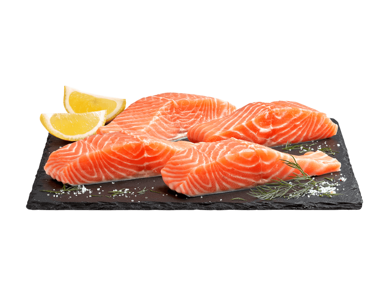 Filets de saumon frais avec citron, aneth et sel marin sur une ardoise foncée.