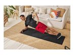 Man in black t-shirt and red shorts doing a side plank on a black exercise mat.