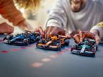 LEGO Formula 1 race cars being played with by people.