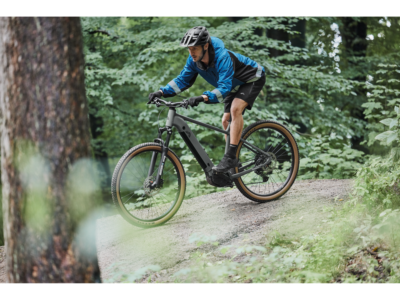 Un bărbat merge cu o bicicletă electrică de munte prin pădure.