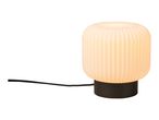 Modern table lamp with a ribbed glass shade and a black base