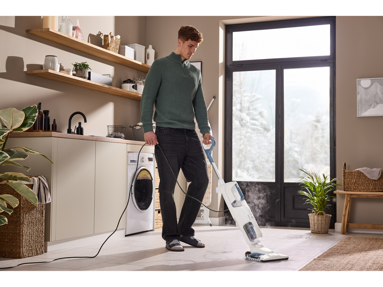 Férfi takarít padlót Silvercrest® 3 az 1-ben gőztisztítóval egy modern háztartási helyiségben.