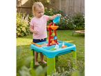 A child playing with a sand and water table in a garden.
