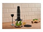 Black hand blender set with chopper, beaker and blending attachment on a wooden countertop