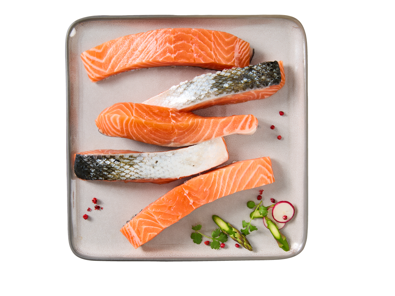 Filetes de salmão crus com pele num prato retangular, com guarnições.