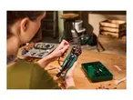 Person using wire strippers to prepare electrical wires, with a component box nearby.