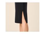 Close-up of a black skirt with a side slit, revealing a leg.