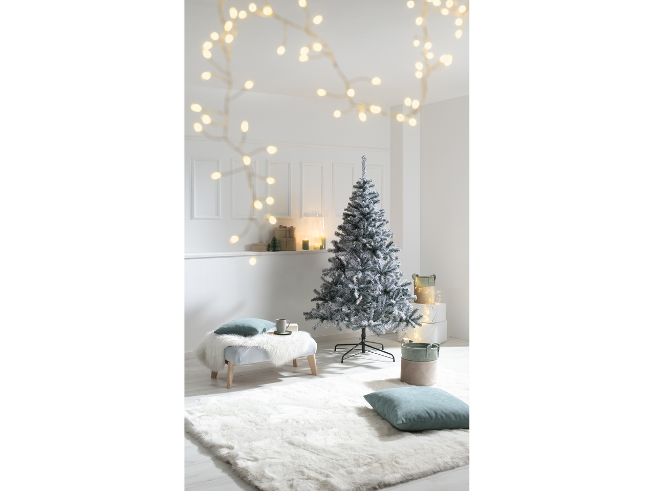 Livarno Home umjetno božićno drvce sa snijegom u dnevnoj sobi s blagdanskim ukrasima.