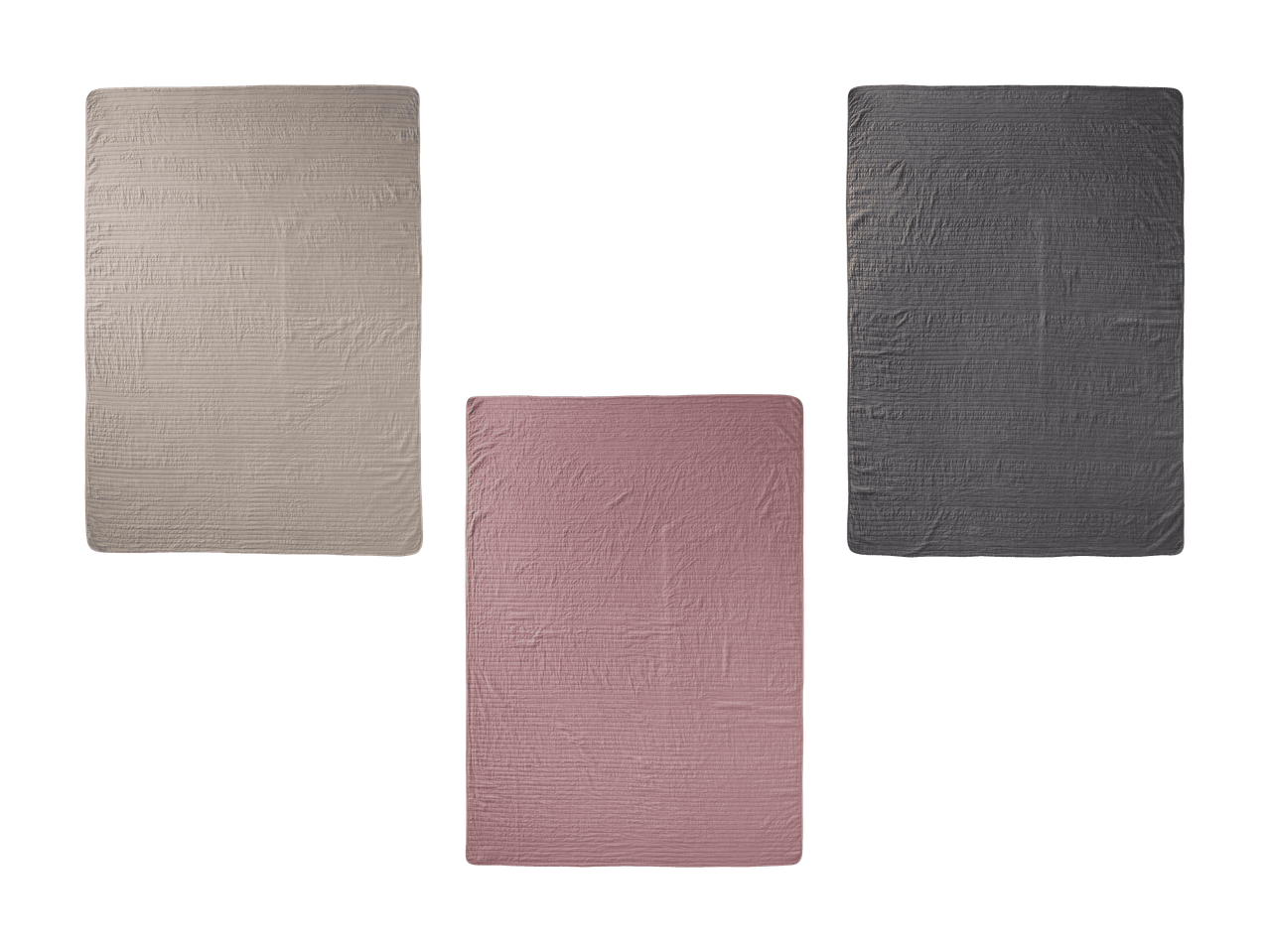 Drei gesteppte Tagesdecken in Beige, Rosa und Dunkelgrau auf schwarzem Hintergrund.