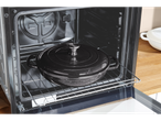 Oală neagră SilverCrest din fontă în interiorul unui cuptor modern pe un grătar metalic.
