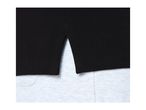 Close-up of a black polo shirt with side slits over light grey fabric.