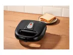 Black sandwich maker on a wooden counter with two slices of bread on a plate.