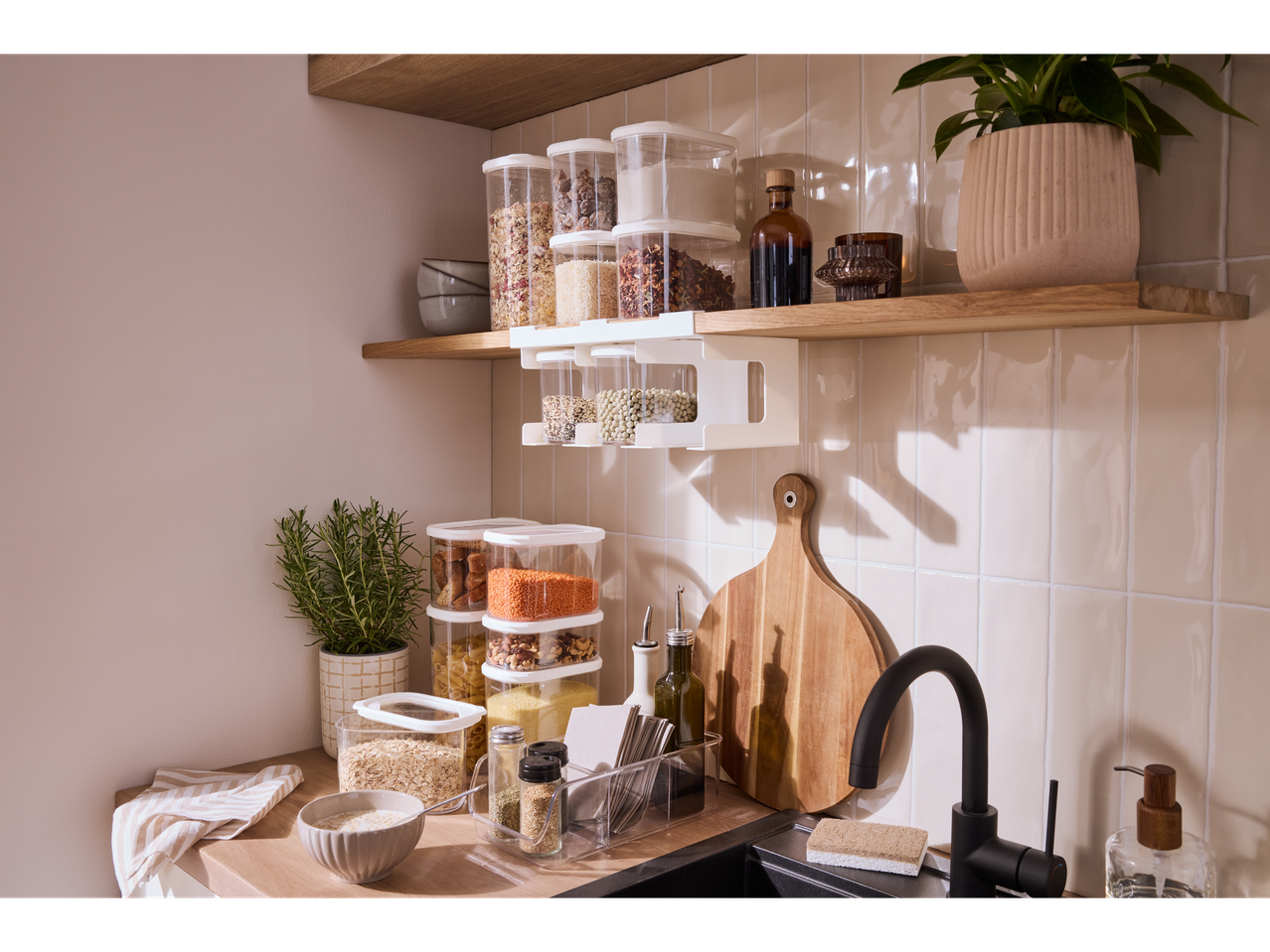 Bancada de cozinha com prateleiras de madeira, recipientes transparentes Silvercrest® para produtos secos e lava-loiça preto.
