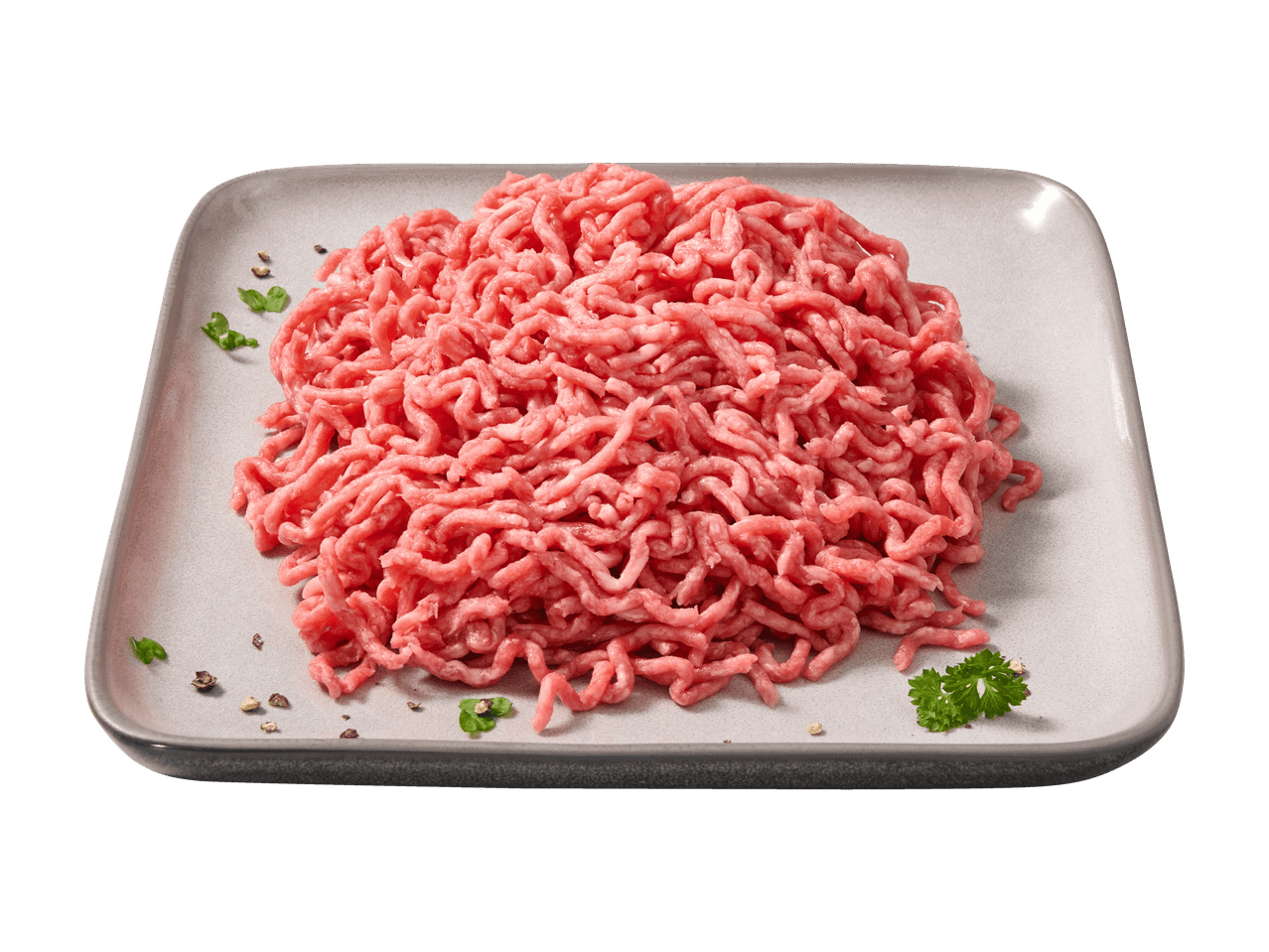 Frisches Hackfleisch auf einer grauen Platte, garniert mit Kräutern und Pfeffer.