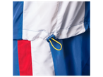 Detalhe de jaqueta corta-vento azul, branca e vermelha; cordão visível.