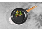 Frigideira de alumínio SILVERCREST com vegetais salteados sobre fundo de concreto.