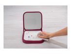 A hand wiping colorful drawings off a red-bound whiteboard on a wooden surface.