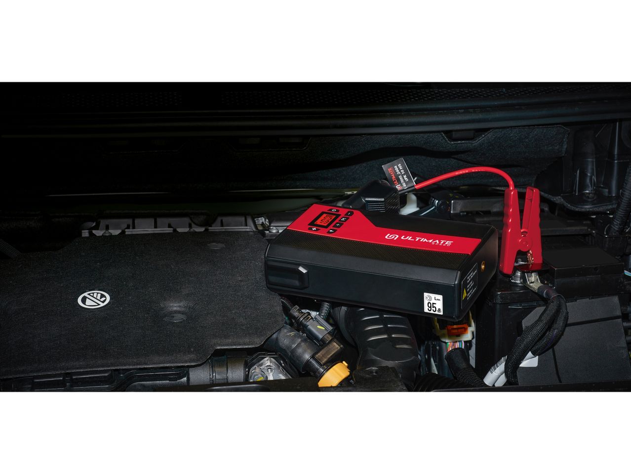 Ultimate Speed jump starter connected to a car battery in an engine bay.