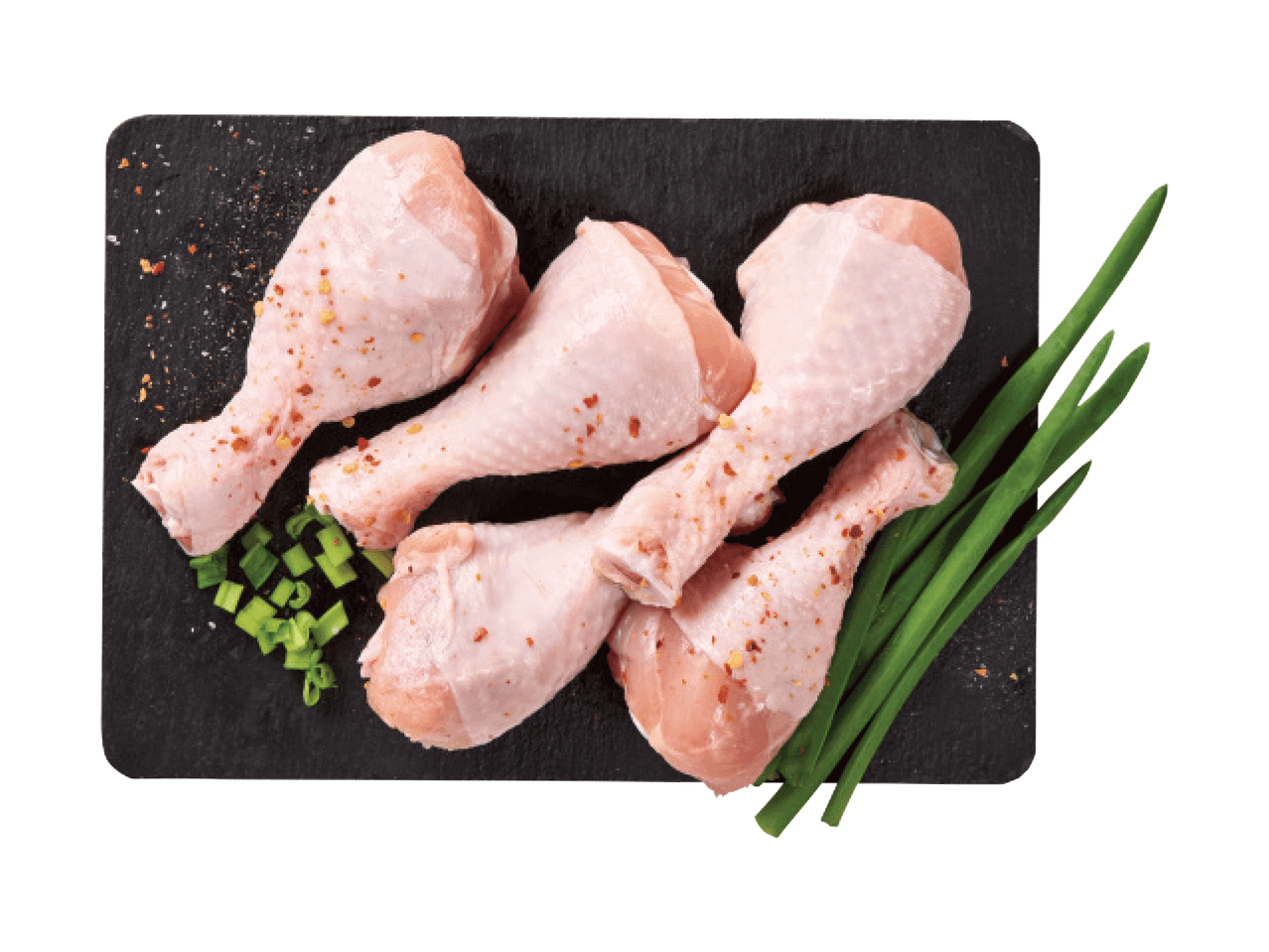 Toored kanakoivad rohelise sibula ja vürtsidega mustal laual.