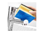 Hand holding a yellow and black sponge with a blue cleaning cloth, cleaning a chrome faucet.
