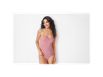 A woman smiles while wearing a pink lace camisole and underwear.