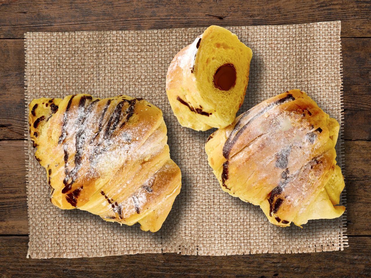 Drei Schokoladencroissants auf einer Juteunterlage.