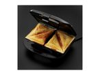 Open sandwich maker with two golden-brown toasted sandwiches inside, on a dark background.