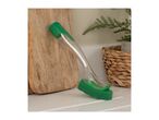 Green dishwashing brush with a sponge head, leaning against a wooden cutting board.