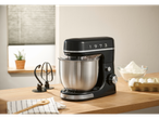 Impastatrice planetaria nera SILVERCREST® con ciotola e accessori su un tagliere di legno.