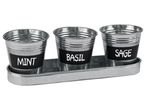 Set di tre vasi in metallo con etichette per erbe aromatiche: menta, basilico e salvia.
