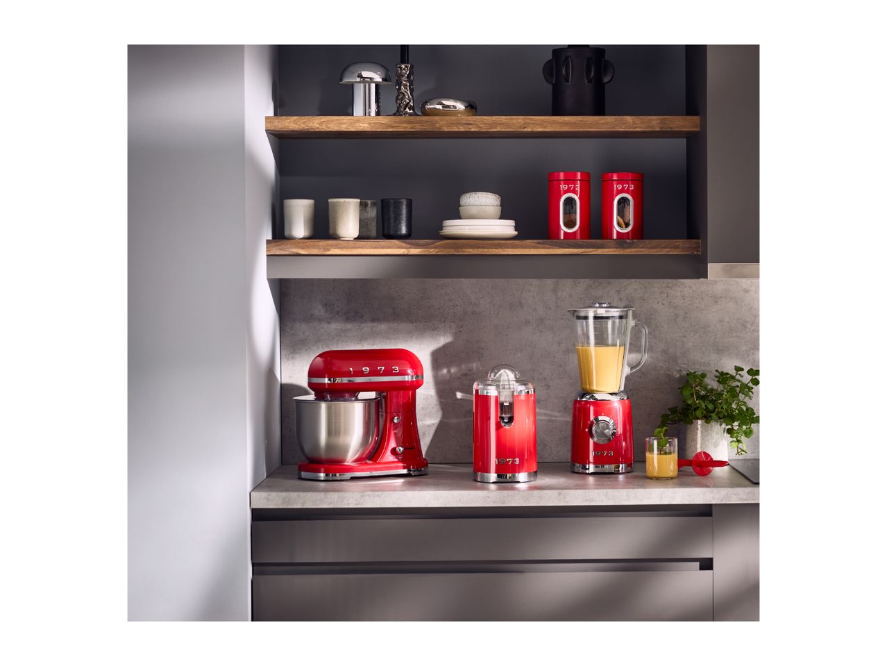 Red retro-style kitchen appliances including a stand mixer, juicer, and blender on a countertop.