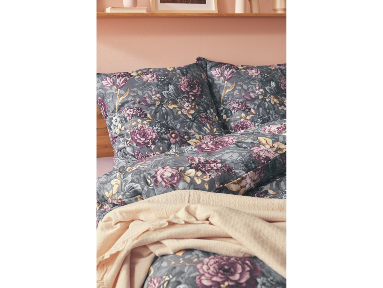 Floral bedding with pillows and a light throw blanket.