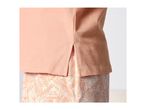 Close-up of a peach-colored top with side slits over patterned shorts.