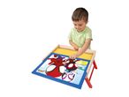 A young boy playing with a Spider-Man themed wooden activity table.