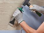 Ένας εργάτης χρησιμοποιεί σφυρί και κόφτη πλακιδίων για να τοποθετήσει πλακάκια.
