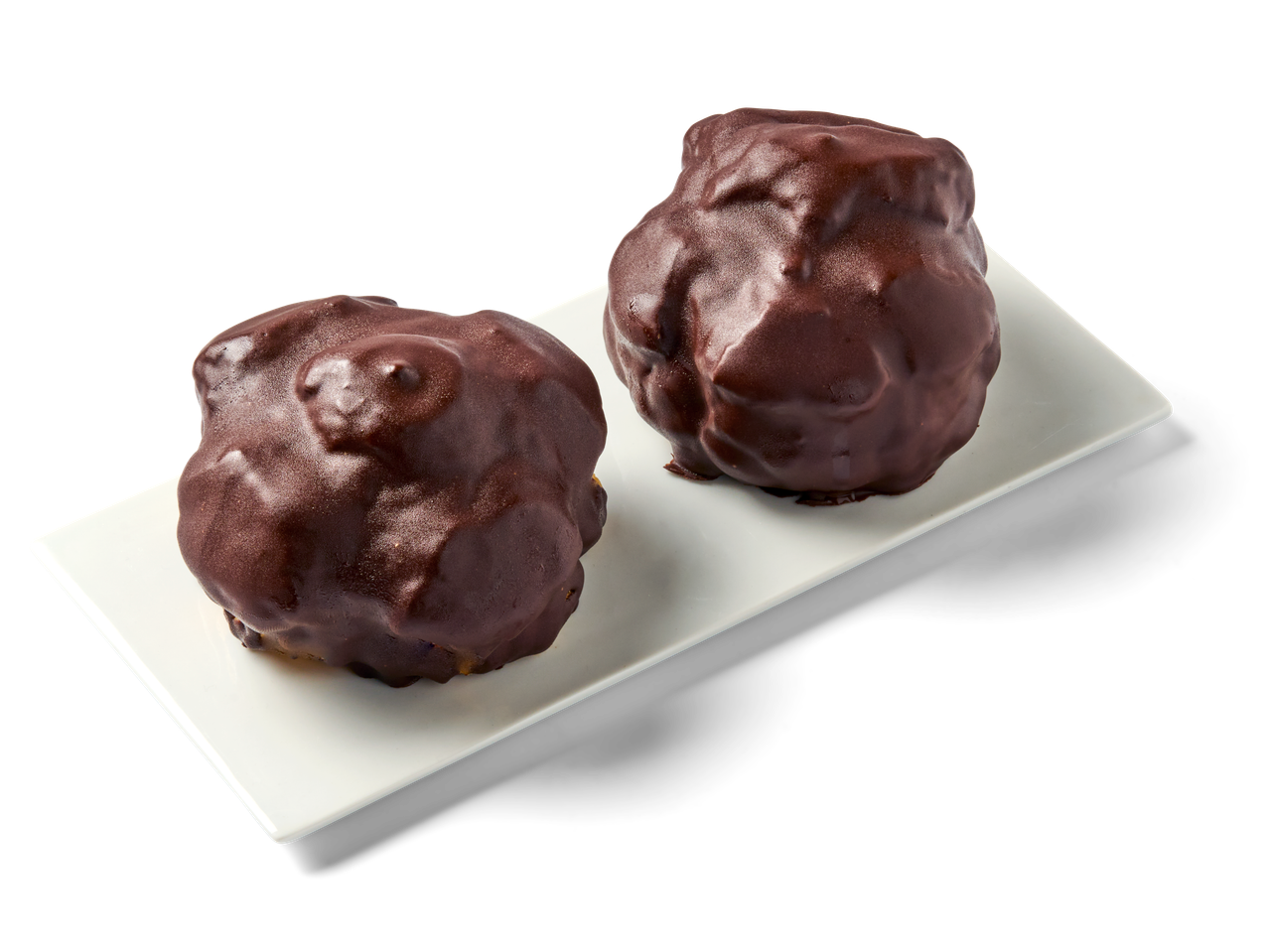 Twee met chocolade bedekte roomgebakjes liggen op een wit rechthoekig bord.