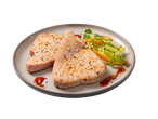 Filetes de atum grelhados com vegetais e molho num prato.