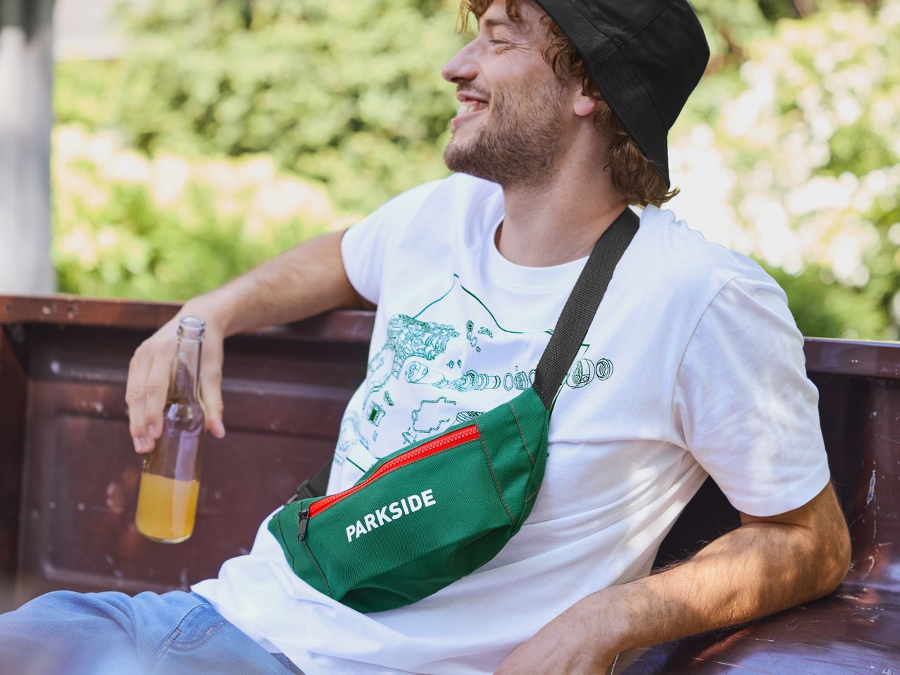 Мъж облечен с бяла тениска и зелена чанта за кръста Parkside®.