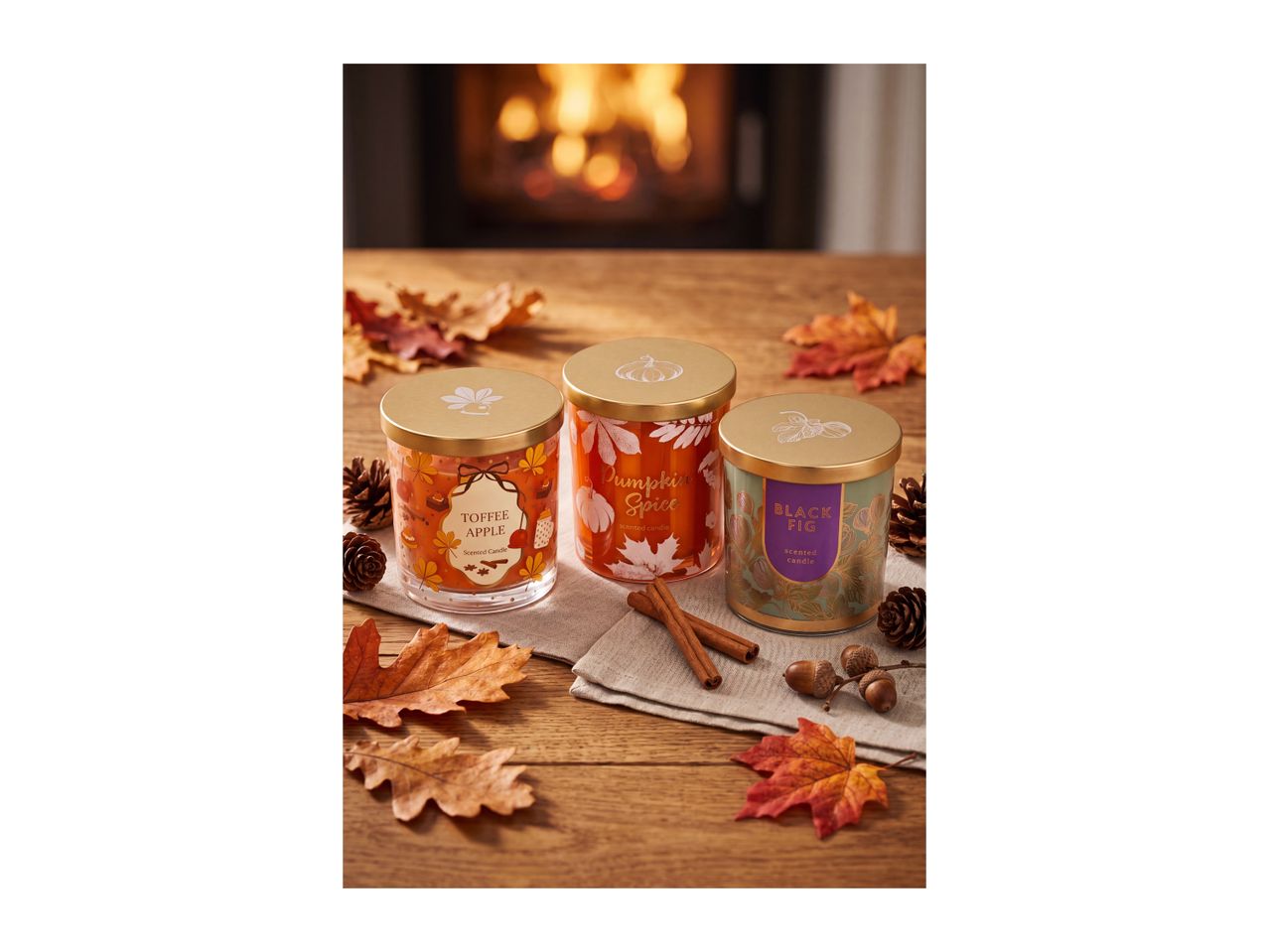 Three autumn-themed scented candles: Toffee Apple, Pumpkin Spice, and Black Fig.
