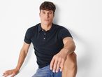 Мъж с къса кафява коса, облечен в тъмносиня тениска с яка Esmara Men®.