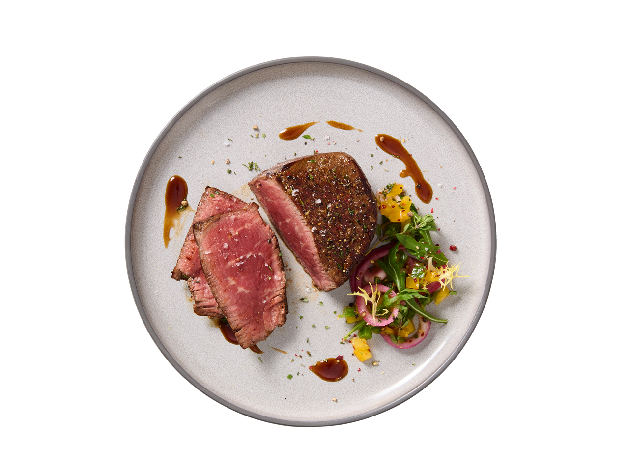 Bife de lombo com salada de manga e cebola roxa num prato cinzento.