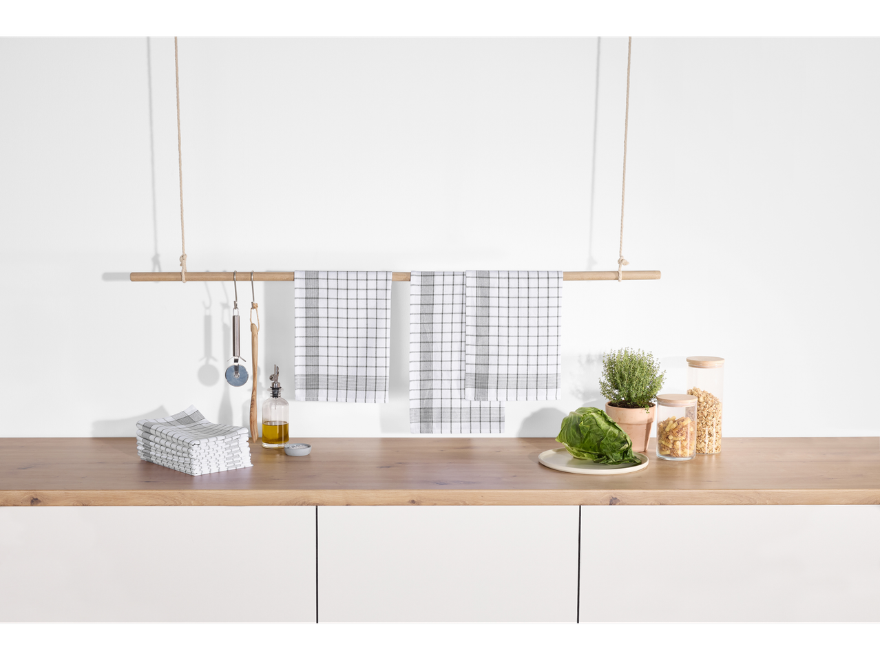 Panos de cozinha W5, pack de 10, pendurados sobre uma bancada de cozinha.