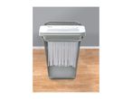 TRONIC paper shredder with a mesh wastebasket, shredding documents.