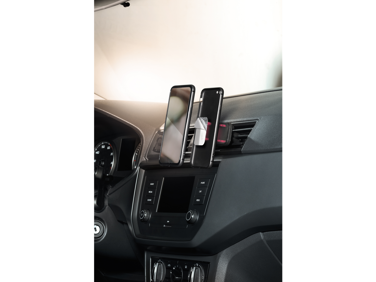 ULTIMATE SPEED® Smartphone Holder in a car, mounted on the dashboard with two phones.