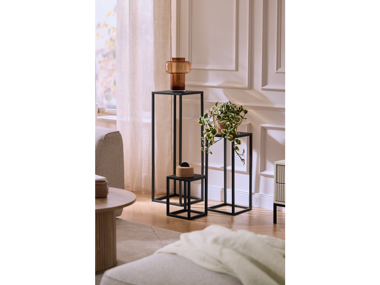 Dekorativni stalci s vazom i lončanicom u dnevnoj sobi.