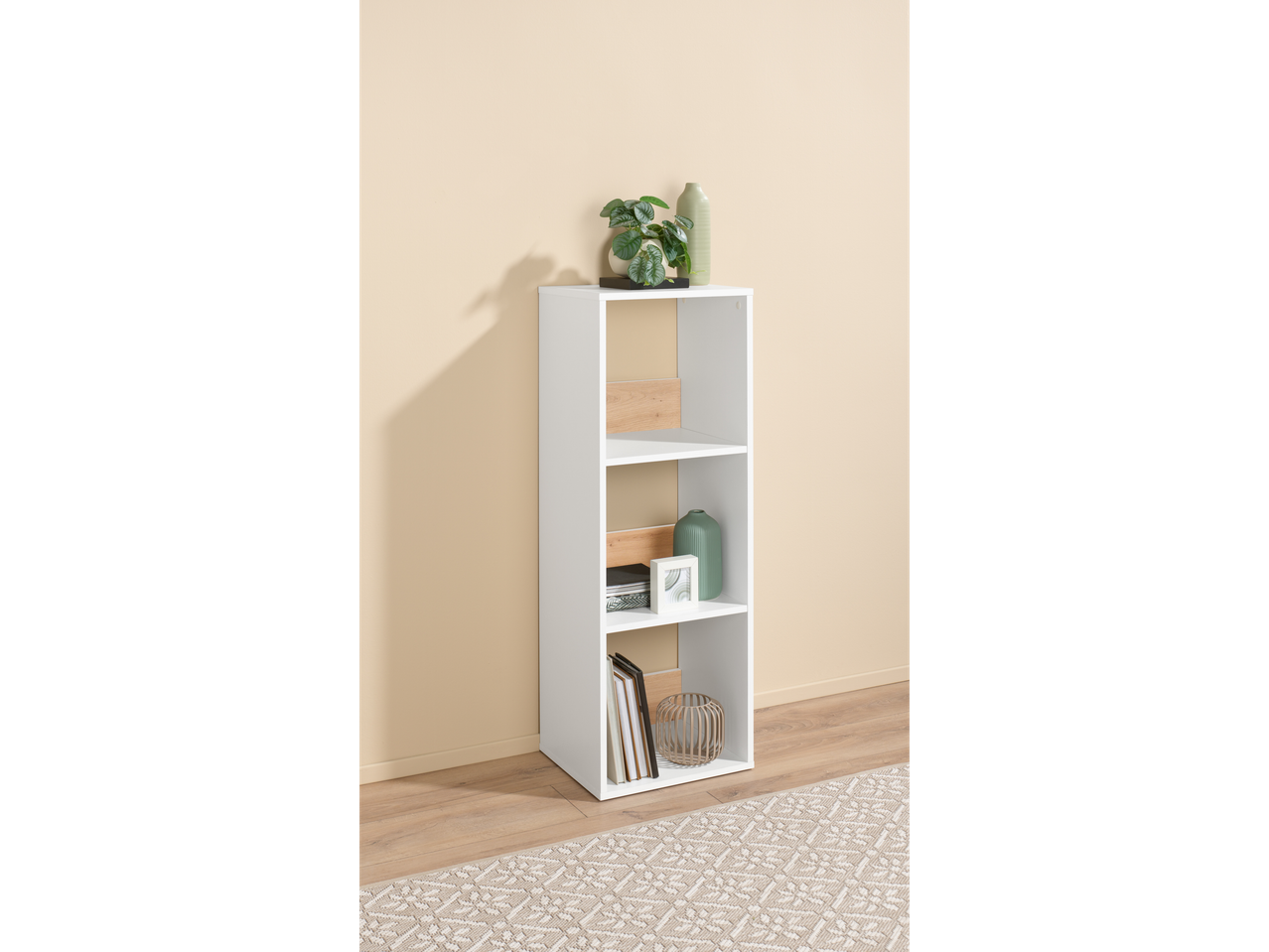 Estante branca de três níveis com itens decorativos.
