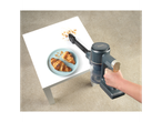 A hand holds a Belladot handheld vacuum cleaner to clean crumbs from a table.