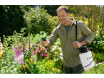 Man using a Parkside 4V Cordless Pressure Sprayer on flowers in a garden.