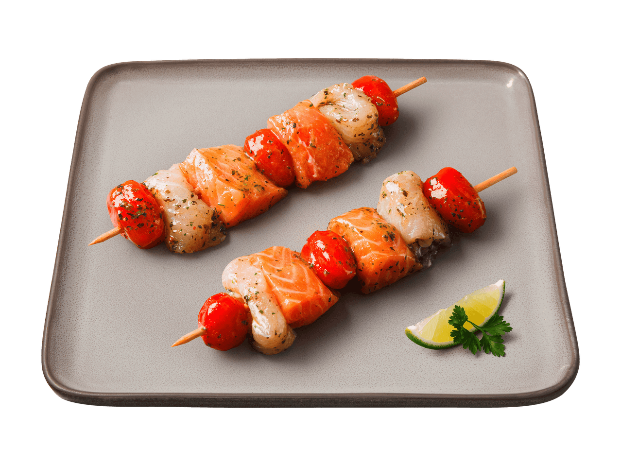 Brochettes de saumon et crevettes avec tomates cerises, garnies de citron vert et persil.