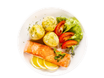 Grilled salmon fillet served with boiled potatoes, tomato salad, and lemon wedges.